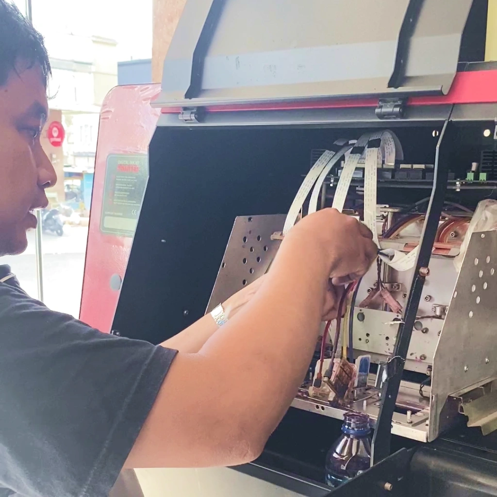 Teknisi Profesional Sedang Melakukan Perawatan Pada Mesin Digital Printing Untuk Menjaga Kinerjanya.