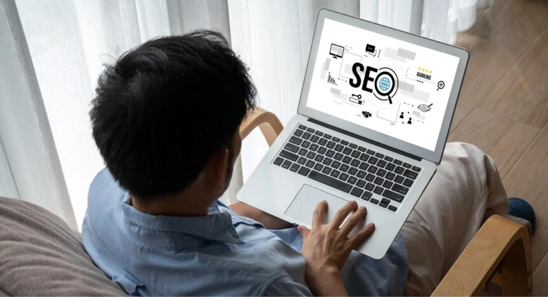 Pria Menggunakan Laptop Untuk Mengoptimalkan Seo Dalam Bisnis Percetakan Online.