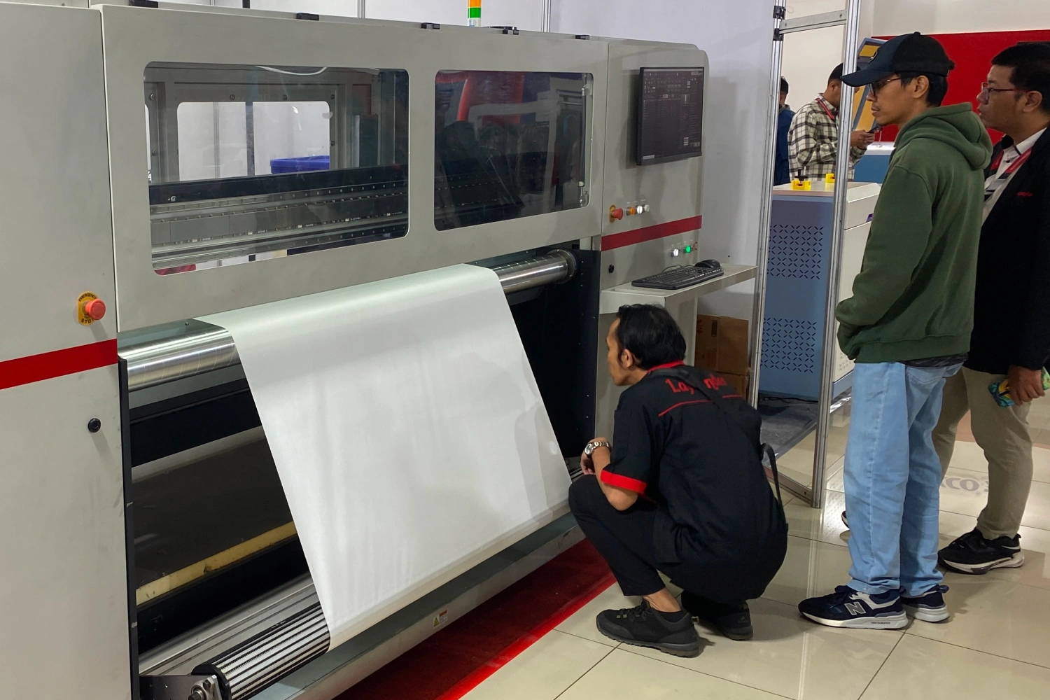 Teknisi Sedang Berbicara Dengan Pengunjung Di Depan Mesin Printer Laysander.