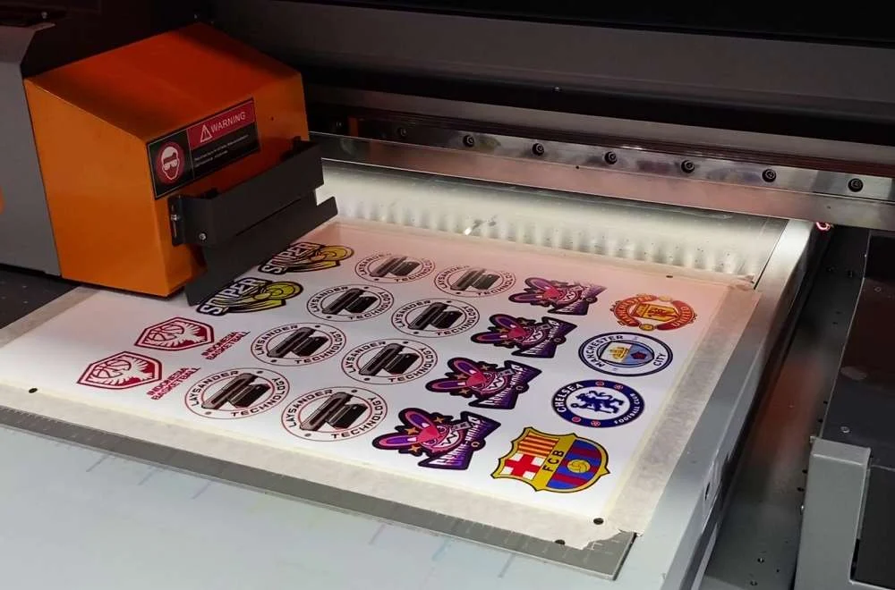 Mesin Uv Flatbed Mencetak Berbagai Desain Patch Dan Stiker Custom Dengan Warna Tajam Serta Detail Presisi Untuk Kebutuhan Produksi Kreatif.